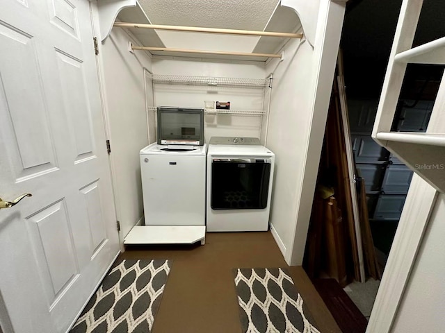 washroom featuring washing machine and dryer and a textured ceiling