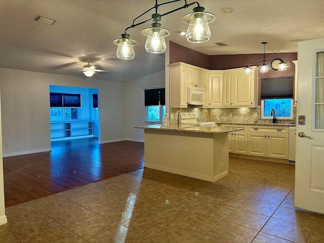 kitchen with light stone counters, white appliances, ceiling fan, white cabinetry, and hanging light fixtures