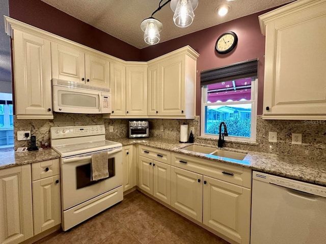 kitchen with sink, light stone counters, a textured ceiling, white appliances, and decorative backsplash