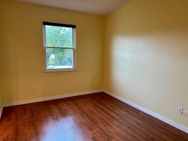 unfurnished room featuring dark hardwood / wood-style flooring and a textured ceiling