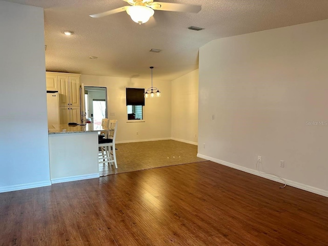 unfurnished living room featuring a textured ceiling, ceiling fan, and dark wood-type flooring