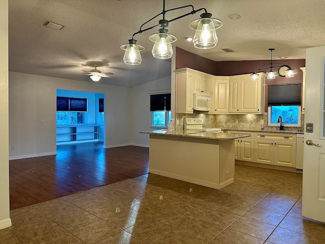 kitchen with light stone countertops, white appliances, decorative light fixtures, white cabinets, and tile patterned flooring