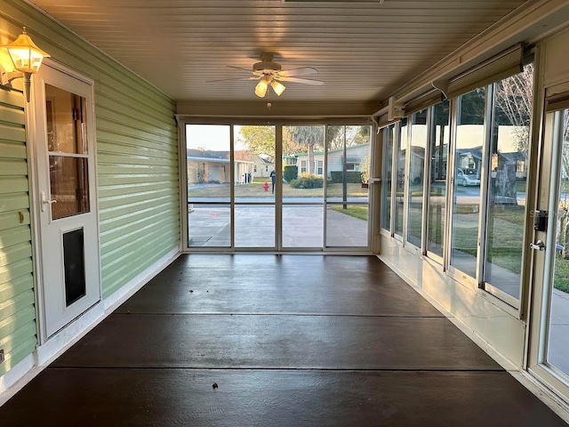 unfurnished sunroom featuring ceiling fan