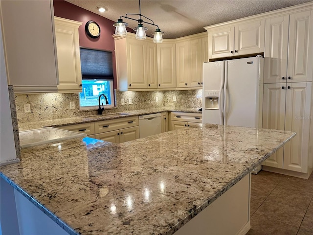 kitchen with pendant lighting, sink, white appliances, light stone countertops, and kitchen peninsula