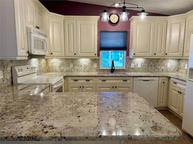 kitchen featuring sink, white appliances, decorative light fixtures, and light stone countertops