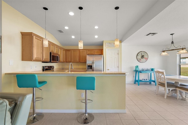 kitchen with a breakfast bar area, hanging light fixtures, and stainless steel appliances