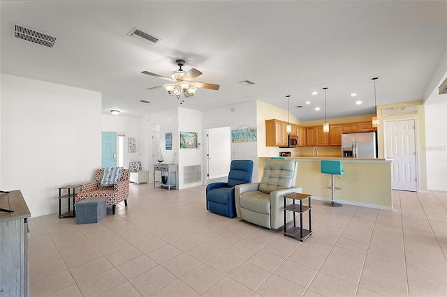 living room featuring ceiling fan, light tile patterned flooring, and sink