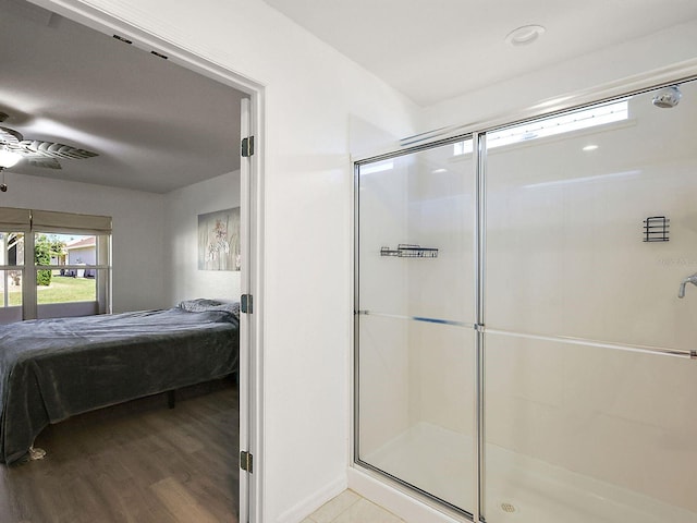 bathroom featuring hardwood / wood-style flooring, ceiling fan, and a shower with door