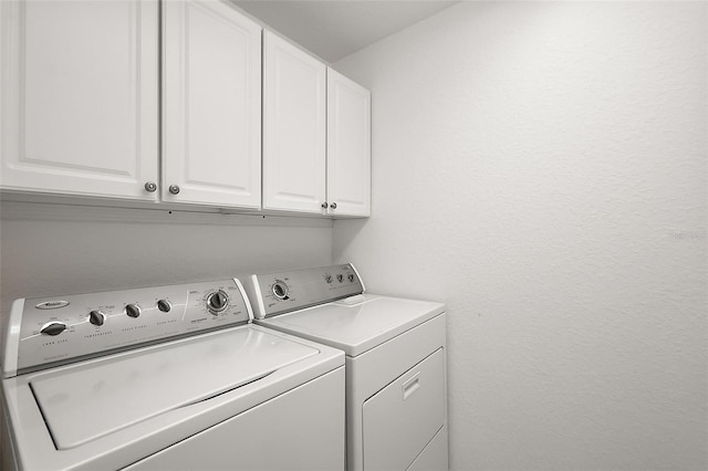 laundry room with washer and dryer and cabinets