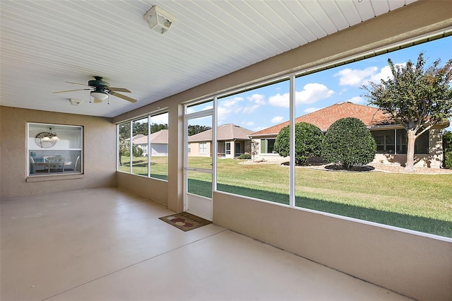 unfurnished sunroom featuring ceiling fan