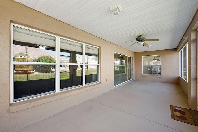 unfurnished sunroom featuring ceiling fan