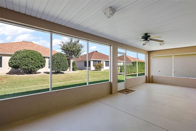 unfurnished sunroom featuring ceiling fan