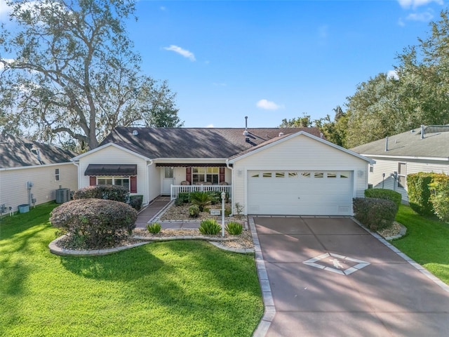 ranch-style home featuring covered porch, a garage, cooling unit, and a front yard