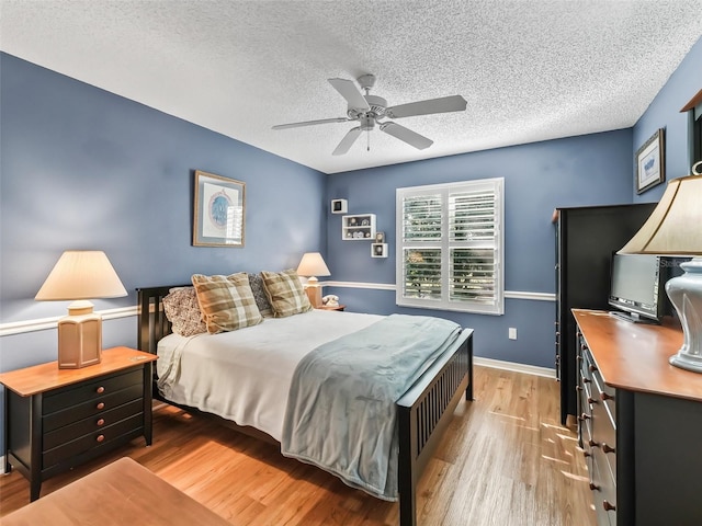 bedroom featuring a textured ceiling, light wood-type flooring, and ceiling fan