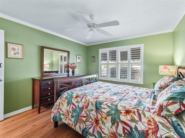 bedroom with a textured ceiling, light hardwood / wood-style flooring, ceiling fan, and ornamental molding