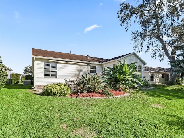 back of property featuring a lawn and central AC unit