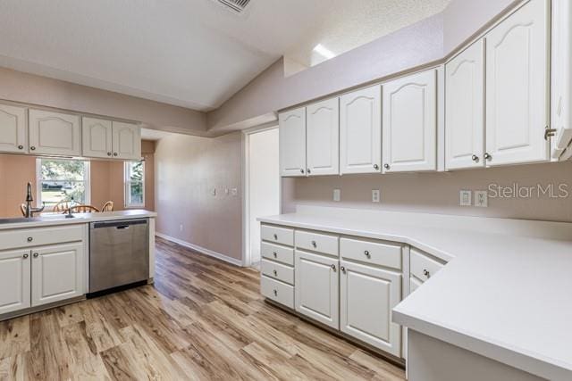 kitchen with stainless steel dishwasher, white cabinetry, lofted ceiling, and light hardwood / wood-style flooring