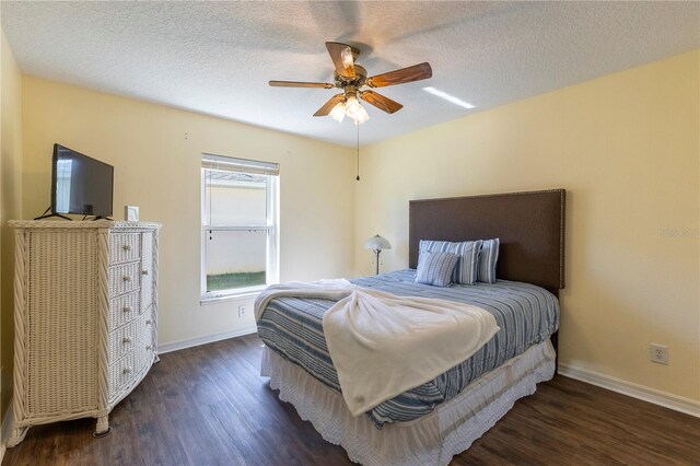 bedroom with a textured ceiling, dark hardwood / wood-style floors, and ceiling fan