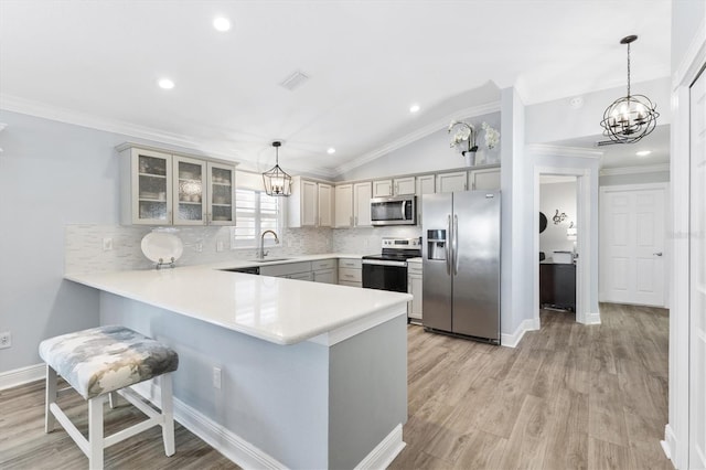 kitchen featuring gray cabinets, lofted ceiling, decorative light fixtures, and appliances with stainless steel finishes