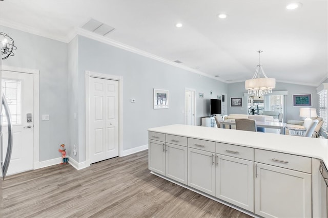 kitchen with a healthy amount of sunlight, light wood-type flooring, crown molding, and a chandelier