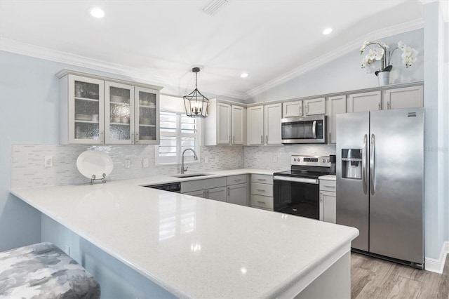 kitchen with sink, crown molding, decorative light fixtures, kitchen peninsula, and stainless steel appliances