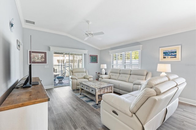 living room with ceiling fan, light wood-type flooring, ornamental molding, and vaulted ceiling