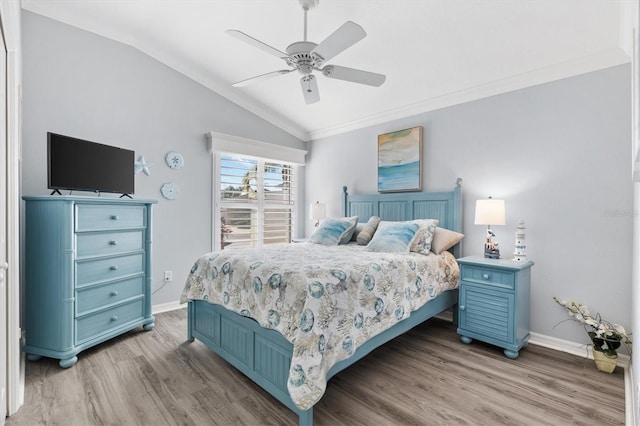 bedroom with ceiling fan, light hardwood / wood-style floors, crown molding, and vaulted ceiling