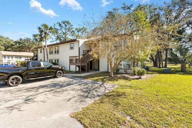 view of front facade with a wooden deck and a front lawn