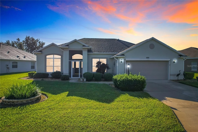 single story home with a lawn and a garage