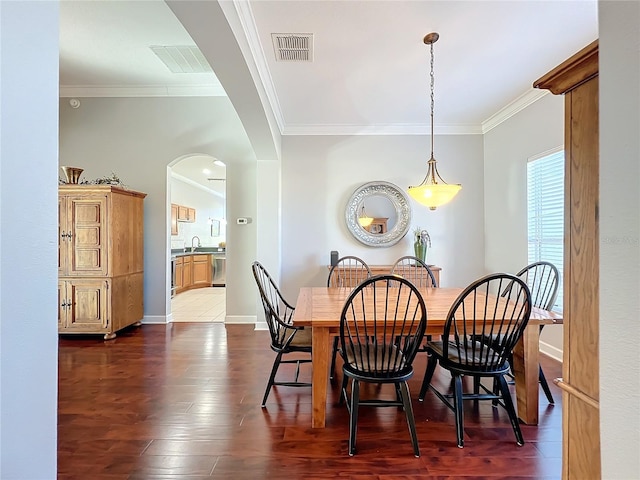 dining room featuring dark hardwood / wood-style floors, sink, and crown molding