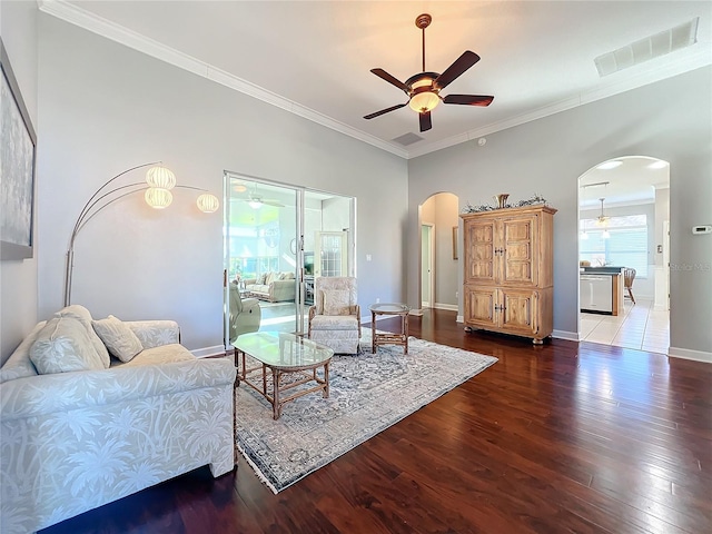 living room featuring hardwood / wood-style floors, ceiling fan with notable chandelier, and ornamental molding