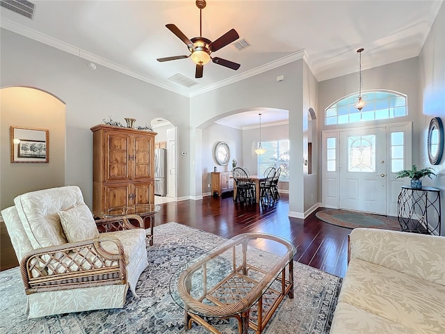 living room with dark hardwood / wood-style floors, ceiling fan, and ornamental molding