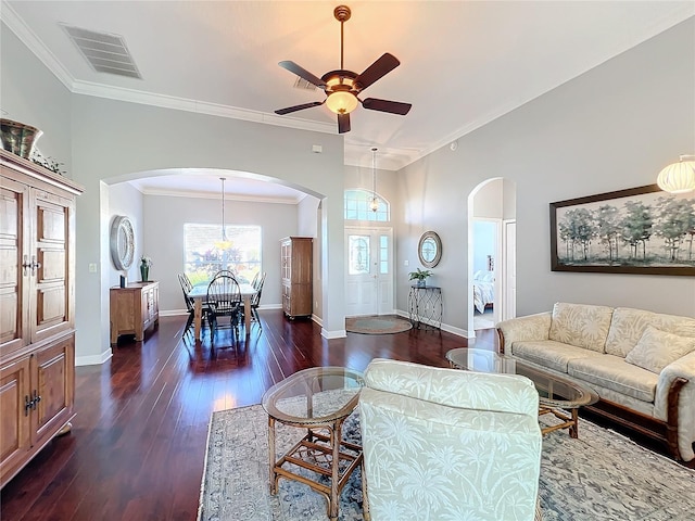 living room featuring dark hardwood / wood-style floors, ceiling fan, and crown molding