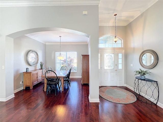 foyer with crown molding, dark wood-type flooring, and an inviting chandelier