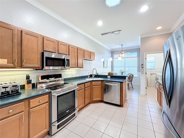 kitchen with sink, crown molding, decorative light fixtures, light tile patterned floors, and appliances with stainless steel finishes