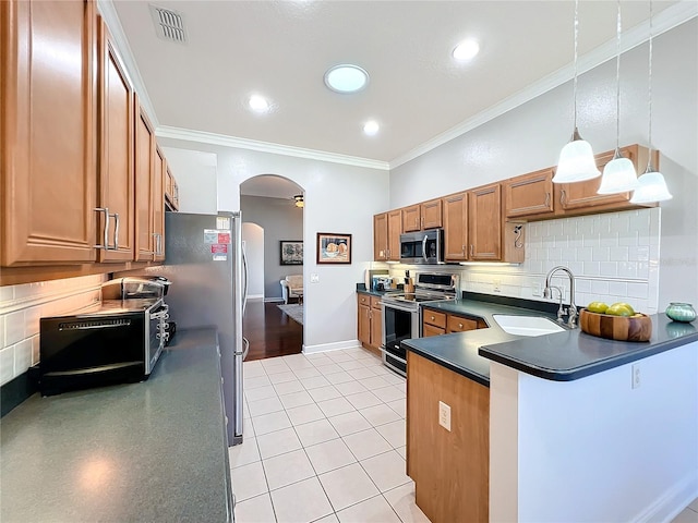 kitchen featuring appliances with stainless steel finishes, crown molding, pendant lighting, and sink