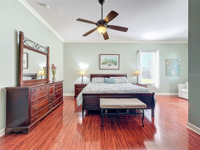 bedroom with ceiling fan, wood-type flooring, a textured ceiling, and ornamental molding