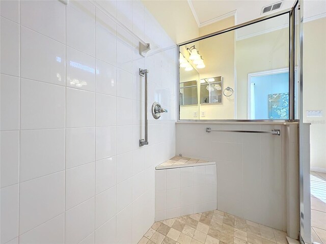 bathroom featuring a tile shower and crown molding