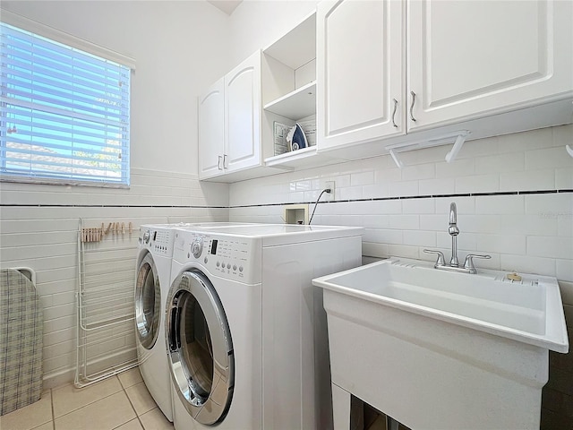 laundry area featuring cabinets, light tile patterned floors, washer and clothes dryer, and sink