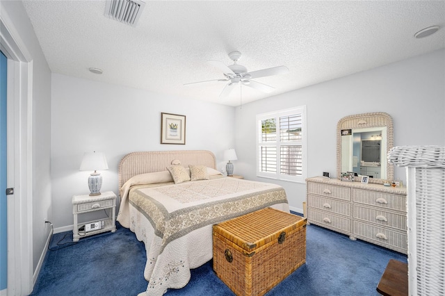 bedroom featuring ceiling fan, a textured ceiling, and dark colored carpet