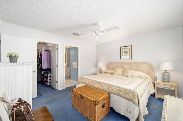 carpeted bedroom featuring connected bathroom, a spacious closet, ceiling fan, a textured ceiling, and a closet