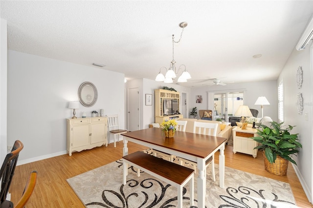 dining room featuring a textured ceiling, ceiling fan with notable chandelier, and light hardwood / wood-style flooring