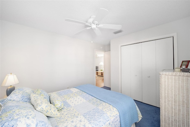 bedroom with carpet flooring, ceiling fan, a textured ceiling, and a closet