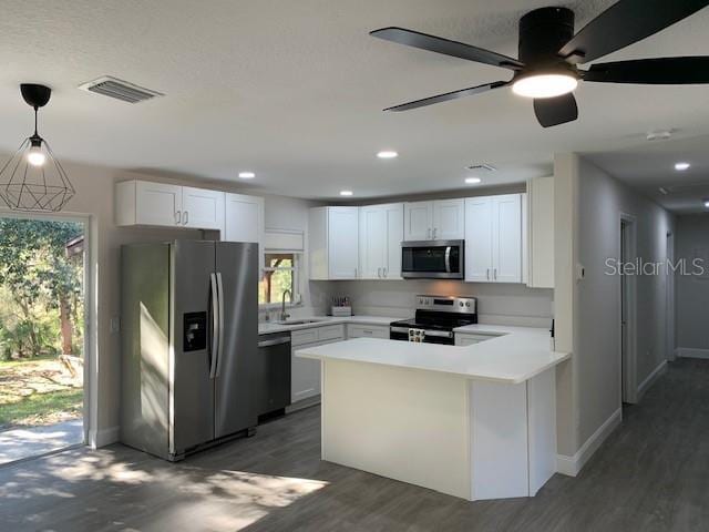 kitchen featuring plenty of natural light, white cabinets, pendant lighting, and appliances with stainless steel finishes