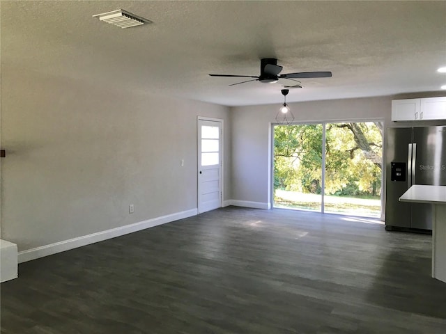 spare room featuring a textured ceiling, ceiling fan, and dark wood-type flooring