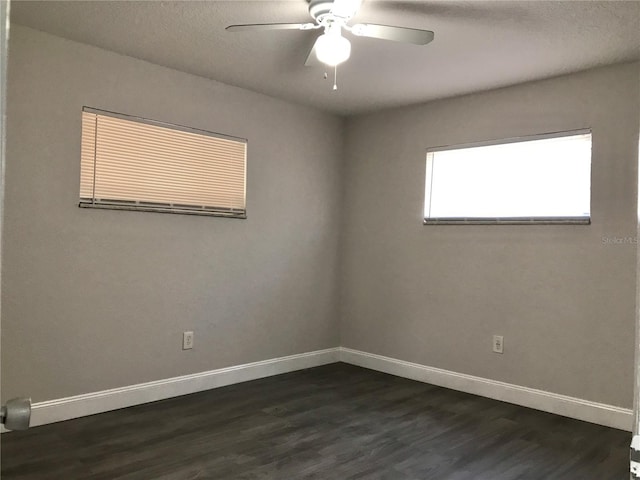 unfurnished room featuring ceiling fan, dark wood-type flooring, and a textured ceiling