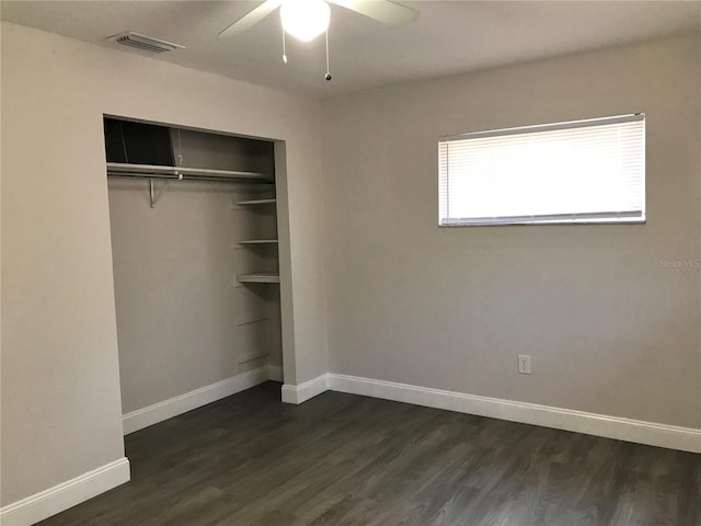 unfurnished bedroom with a closet, ceiling fan, and dark wood-type flooring