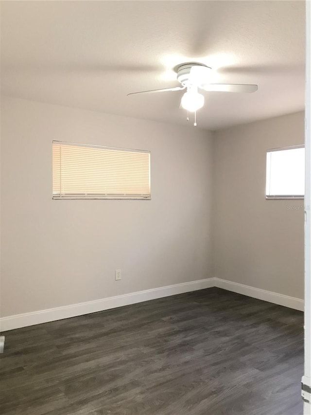 unfurnished room with dark wood-type flooring, baseboards, and ceiling fan