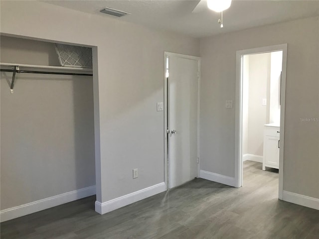 unfurnished bedroom featuring visible vents, wood finished floors, a closet, baseboards, and ceiling fan