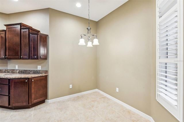 kitchen with decorative light fixtures, dark brown cabinetry, light tile patterned floors, and an inviting chandelier